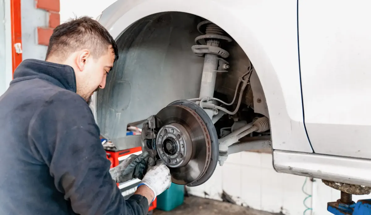 Technician working on a brake disc and caliper