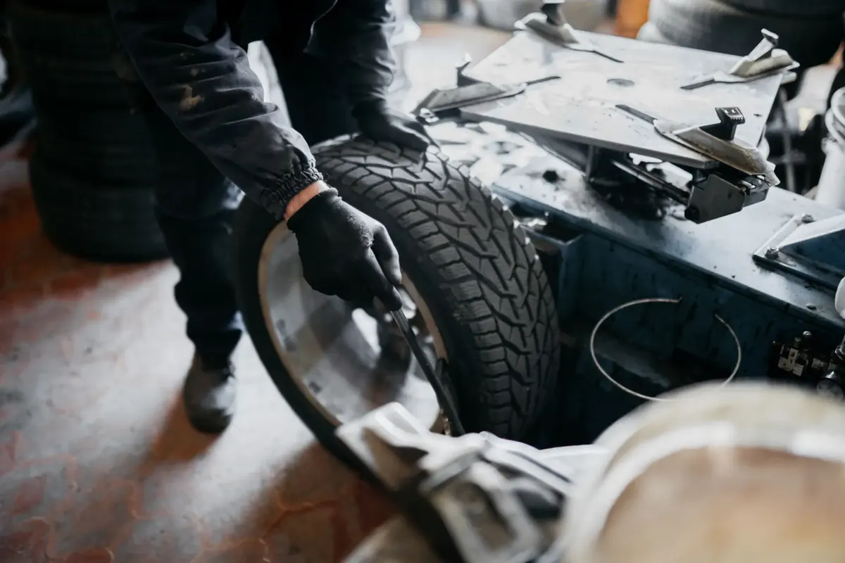 Gloved technician mounting a tire on a wheel